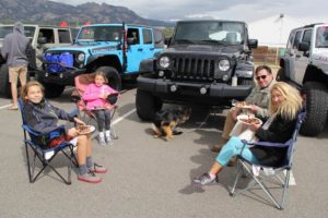 Jeep owners sitting next to their car